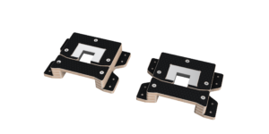 Angled view of two black textured mounting plates with beige edges and a central square cutout, each showing screw holes.